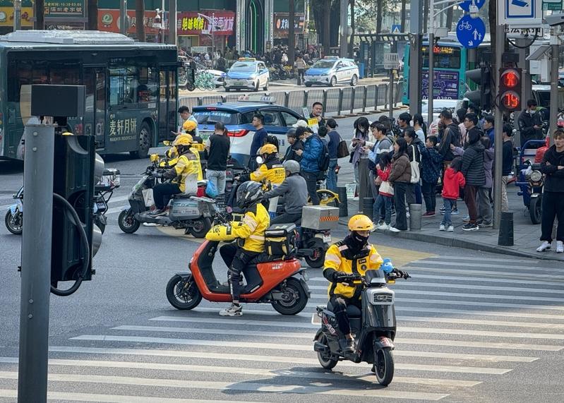 外卖骑手为赶接送单，不时传出发生交通事故。图为外卖骑手在北京国贸送餐。（中新社）