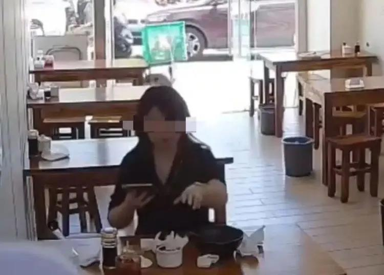 女子餐后将擦鼻涕纸扔进调料罐。(视频截屏)