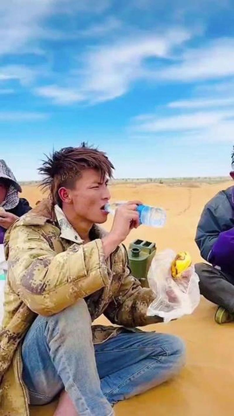 00后「异瞳」男生王金因沙漠喝水视频走红。(取材自抖音)