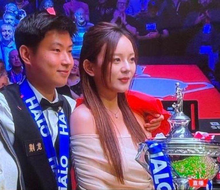 赵心童(左)夺得2025年斯诺克世锦赛冠军，特别感谢自己的女朋友，合影时邀她一同上台。(央视截屏)