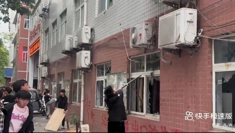 河南许昌市第六中学一名女生因遭老师体罚而跳楼死亡，引发大批民众与学生聚集校园周边声讨，情绪激动的学生砸学校抗议。（视频截屏）
