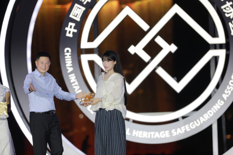 李子柒(右)获聘中国非物质文化遗产保护协会「非遗推广大使」及「青年非遗视频创作哺育行动总顾问」现场。(取材自澎湃新闻)