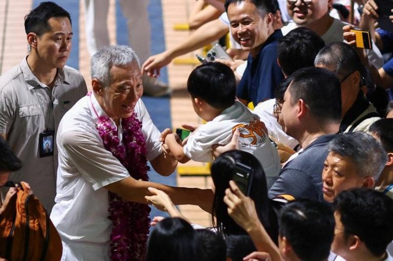 新加坡国务资政李显龙(左二)下海参选国会议员，政见会上不谈自己，而是全力帮人民行动党拉票。（路透）