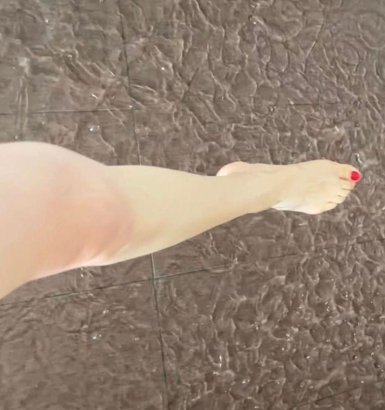 张馨予走在水中，露出涂着红色指甲油的美腿。(取材自微博)