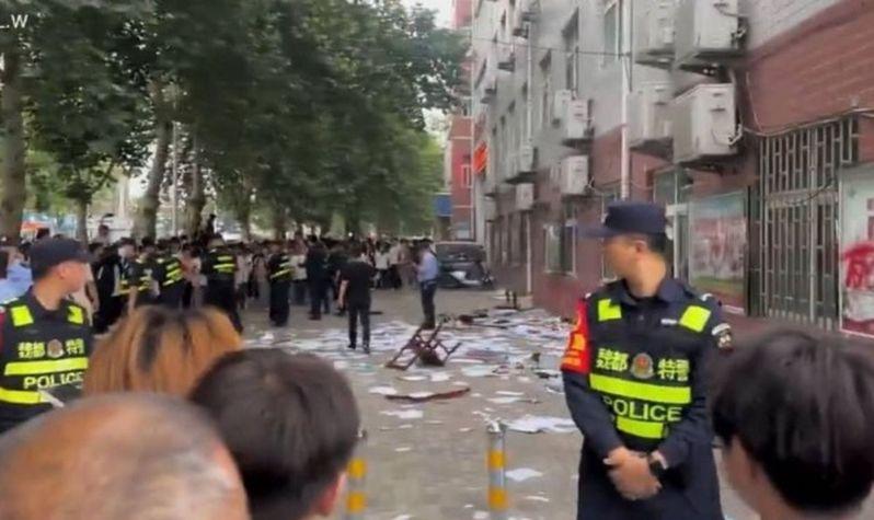 河南许昌市第六中学一名女生因遭老师体罚而跳楼死亡,引发大批民众与学生聚集校园周边声讨,情绪激动的学生砸学校抗议。(视频截屏)