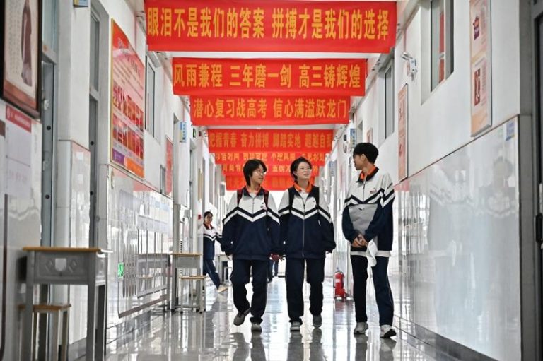 为了在高考取得好成绩，学生从早学习到晚。图为山西省太原市第二十四中学校，高三年级组楼道内悬挂着励志标语。 (中新社)