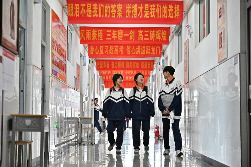 为了在高考取得好成绩,学生从早学习到晚。图为山西省太原市第二十四中学校,高三年级组楼道内悬挂着励志标语。 (中新社)