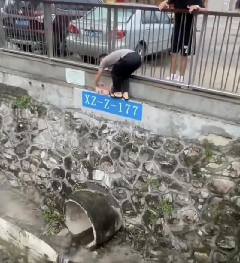深圳一河道惊现大量成捆钞票，一名男子下水将其全部捡走。（取材自极目新闻）