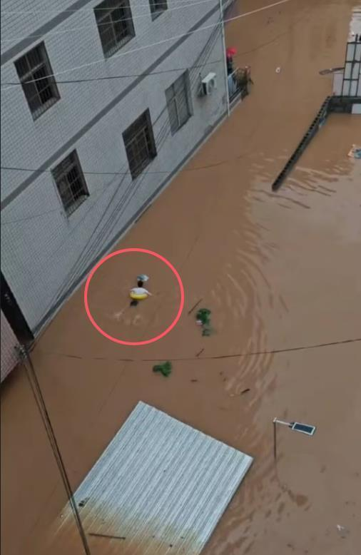 中考遇上暴雨，湖南龙山县一名学生只好游泳出行。（取材自极目新闻）