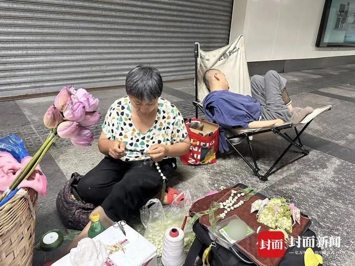 周扬琼在人少的间隙串手串。(取材自封面新闻)