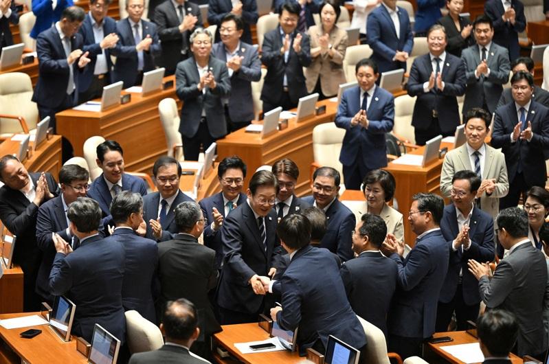 赴国会发表首次施政演说 南韩总统李在明26日抵达国会,先与议员握手致意,随后上台发表施政演说(见图)。(路透)