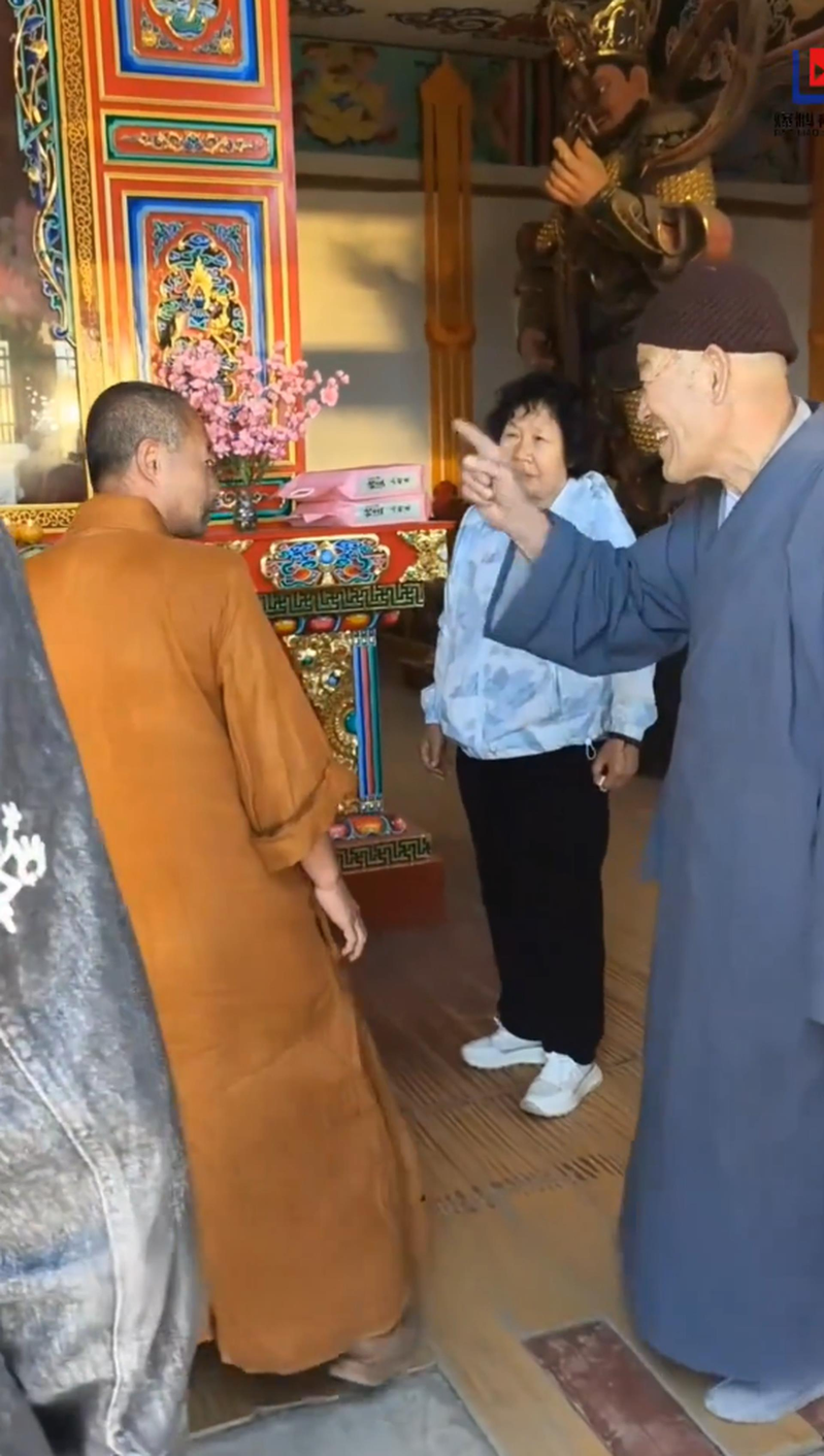 涉事僧人拿起老夫妇放在供桌上的米准备往外扔。(视频截屏)