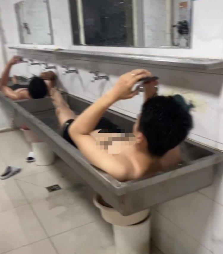 酷热难当,吉林农业大学有学生热到泡在水池里降温。(视频截屏)