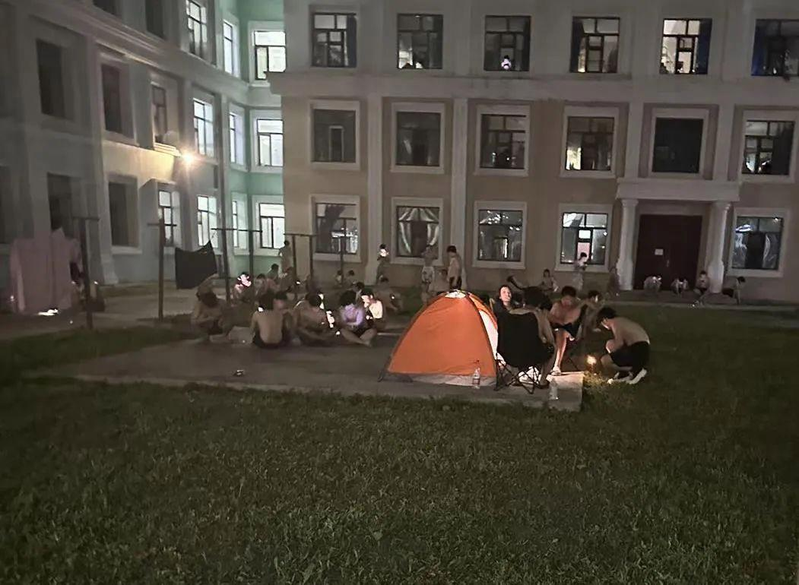 酷热难当，吉林农业大学有学生热到泡在水池里降温。(视频截屏)