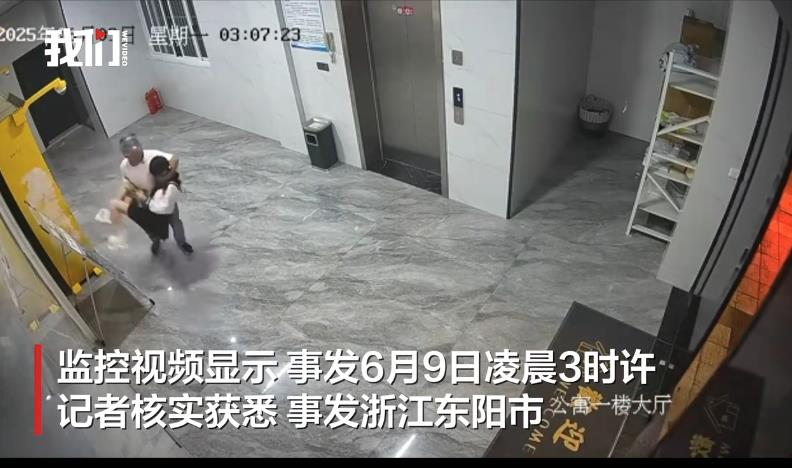 男子抱着女子往梯厅出口走去。(视频截屏)