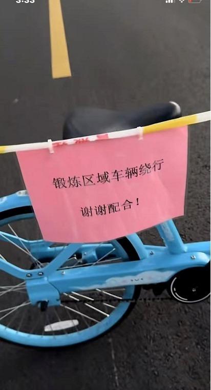 跳广场舞的大妈悬挂一张告示,「锻炼区域车辆绕行,谢谢配合!」 (取材自大风新闻)