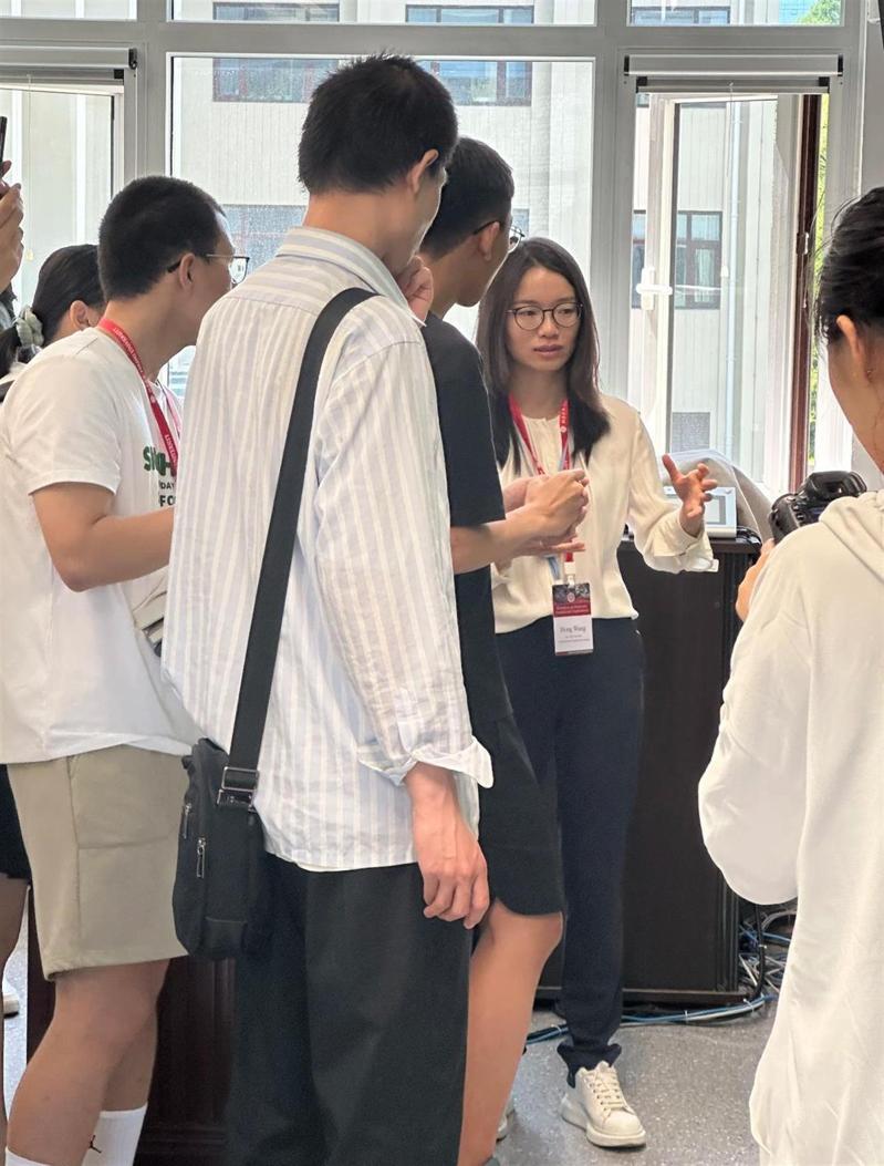 王虹(右二)与韦东奕(前排条纹衣)同框讨论数学问题。(视频截屏)