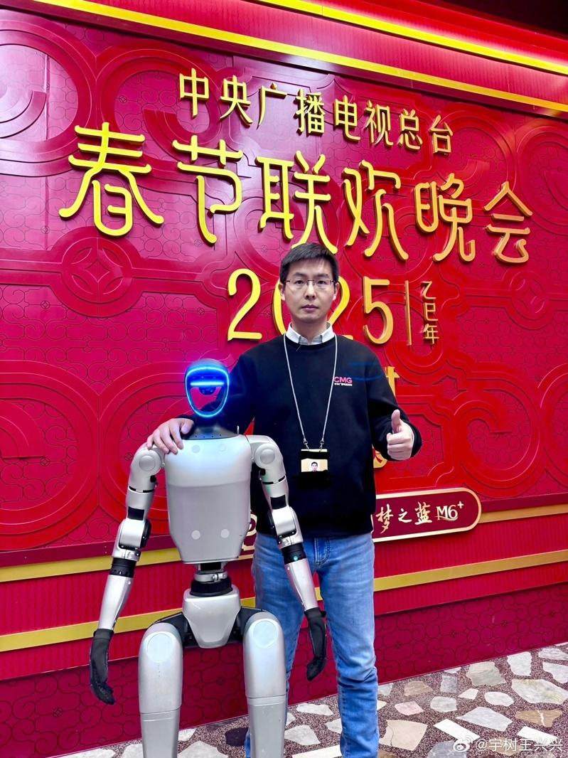 宇树科技创始人王兴兴与他的机器人。(取材自微博)