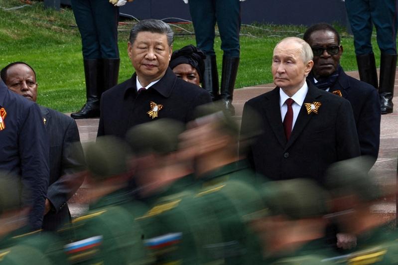 俄罗斯总统普亭(右)与中国国家主席习近平,于俄罗斯莫斯科市中心举行的无名战士墓献花仪式上,一同观看俄军官兵列队行进。(路透数据照)
