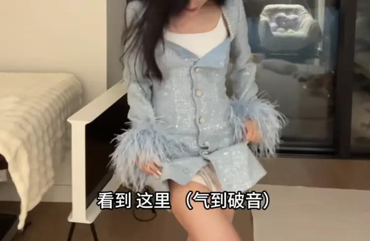女子演示连衣裙上面的扣子爆开，并称自己当时没穿里面这件背心。（视频截屏）