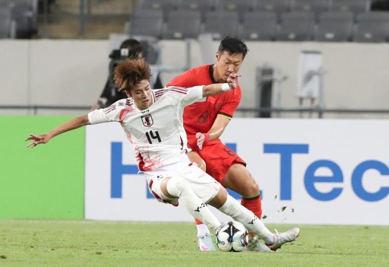 国足在东亚杯以0：2输给日本队，写下27年来没赢过日本的尴尬纪录。图为中国队球员徐新（右）与日本队球员大关友翔在比赛中拚抢。（新华社）