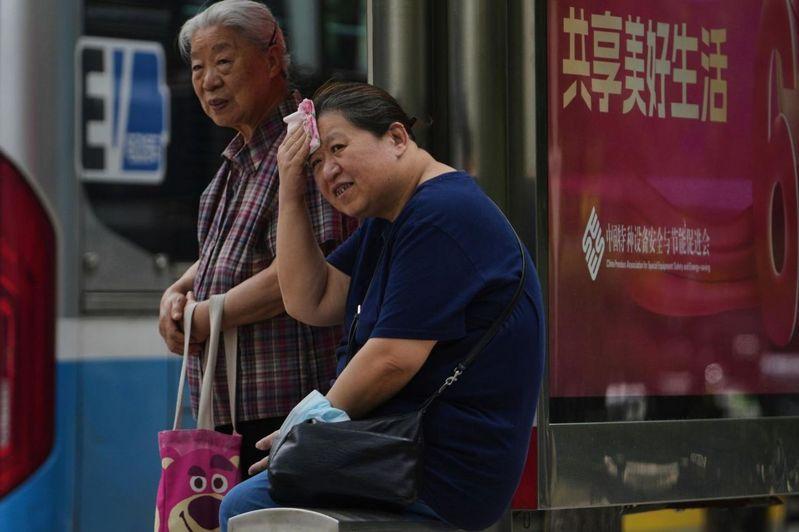 2025年入夏以来,中国高温预警突破2万次。图为女子在北京等公车时以手帕擦汗。(美联社)