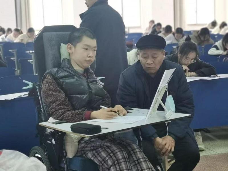 浙江中医药大学党委书记王斌（右）将录取通知书递到徐立芃（左）手中。(取材自潮新闻)