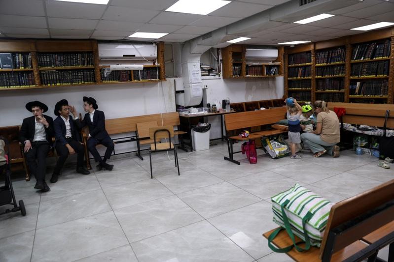 以色列将开始对5万4000名极端正统派犹太教男子征兵,此举可能导致联合政府声明分裂;图为极端正统派犹太人日前待在一座防空洞避难。(路透)