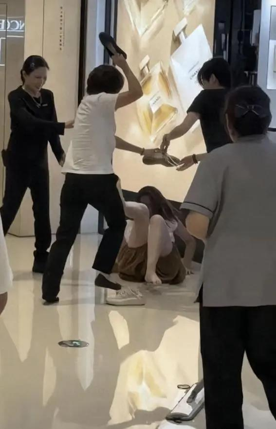 网传视频中，柜姐正在殴打女顾客，另有两名柜姐一左一右拉着女顾客的手臂。(视频截屏)
