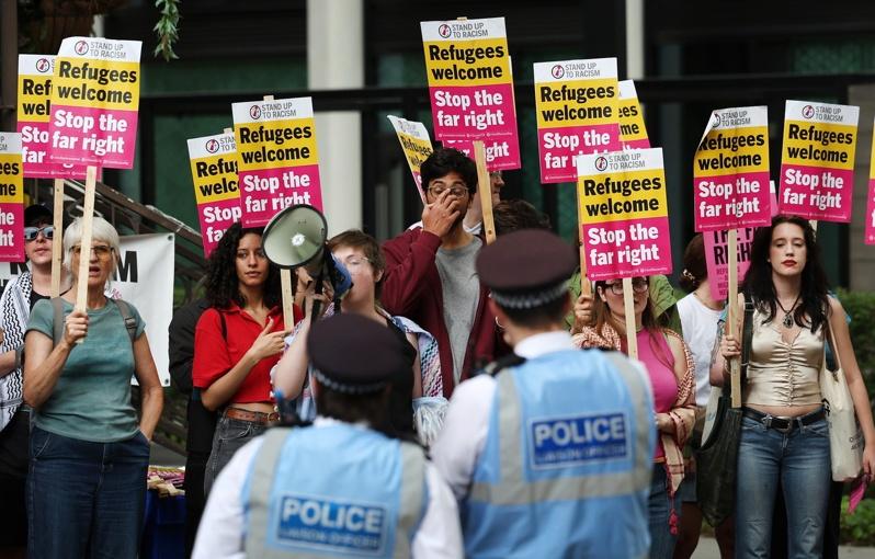 英国近期发生连串反移民示威暴力事件,令人愈来愈担忧今夏将再度爆发大规模动乱。图为25日在英国伦敦一家移民酒店外,抗议者举着标语抗议。(欧新社)