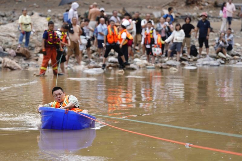 7月28日，在琉璃庙镇碾子湾村，受灾民众乘坐塑料小舟转移到安全地点。（中新社）