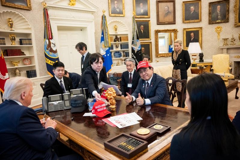 日本经济再生担当相赤泽亮正(右)4月16日拜会美国总统川普时(左),戴上「让美国再次伟大」的帽子示好。(路透)