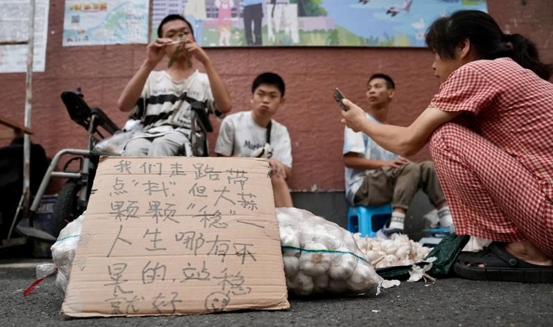 三名脑瘫小伙在出摊的路上。（新华社）