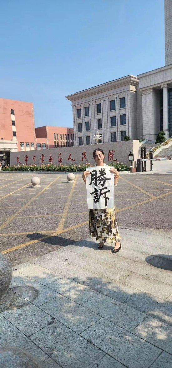 工伤行政诉讼判决胜诉后,崔丽丽在法院门口拍摄。(取材自潮新闻)