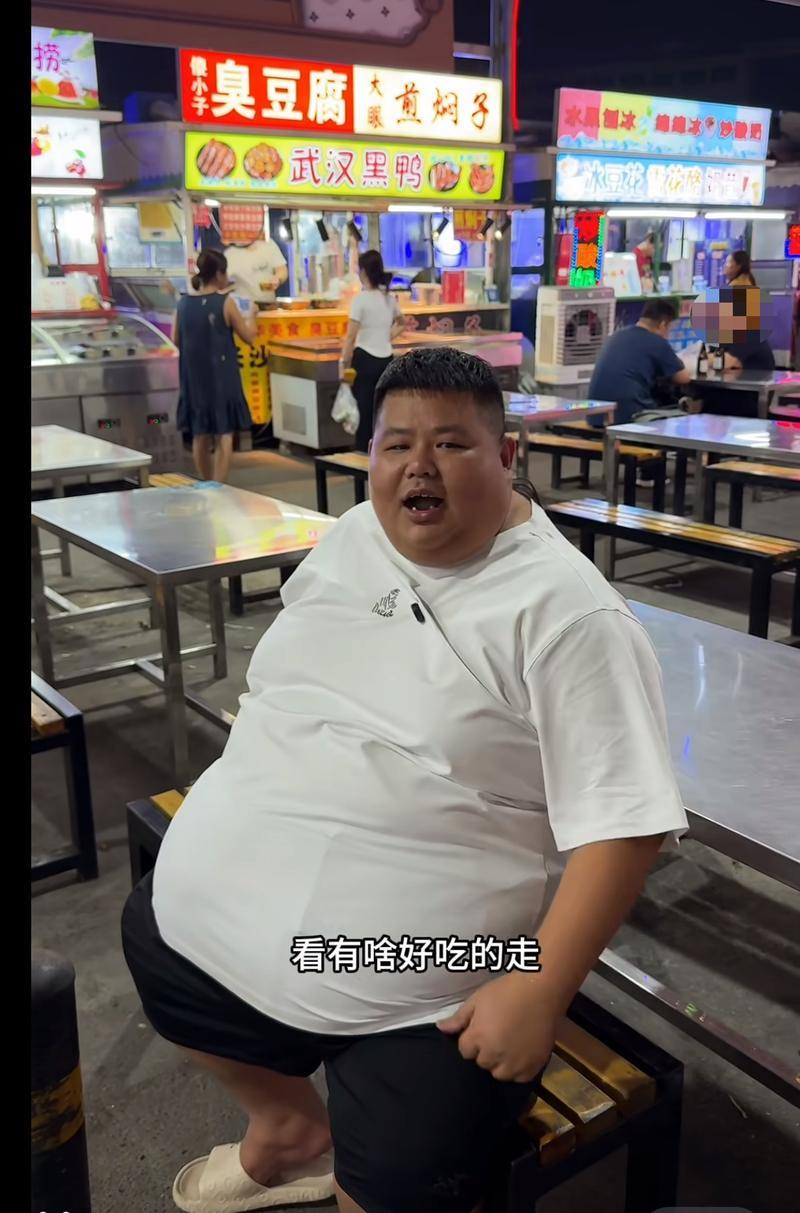 良子来到夜市吃东西,他坐下时突出的肚子几乎跟膝盖齐平。(取材自新京报)