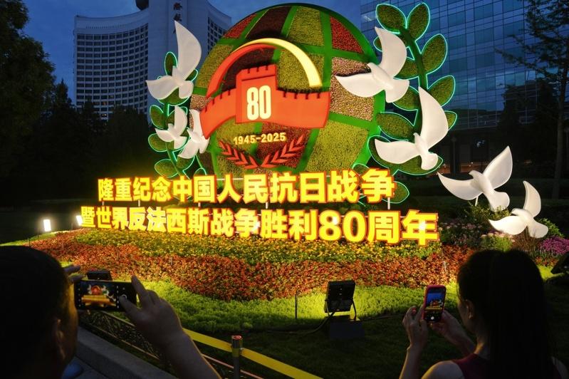 8月22日,亮灯的纪念抗战胜利80周年主题花坛扮靓北京长安街,吸引民众参观打卡。(中新社)
