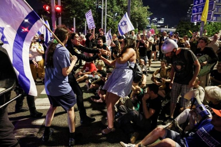 在以色列特拉维夫的示威者和人质亲属5日封锁道路，要求立即释放遭哈马斯绑架的人质，并结束加萨战争。图为以色列女警试图拘留一名抗议者。(路透)