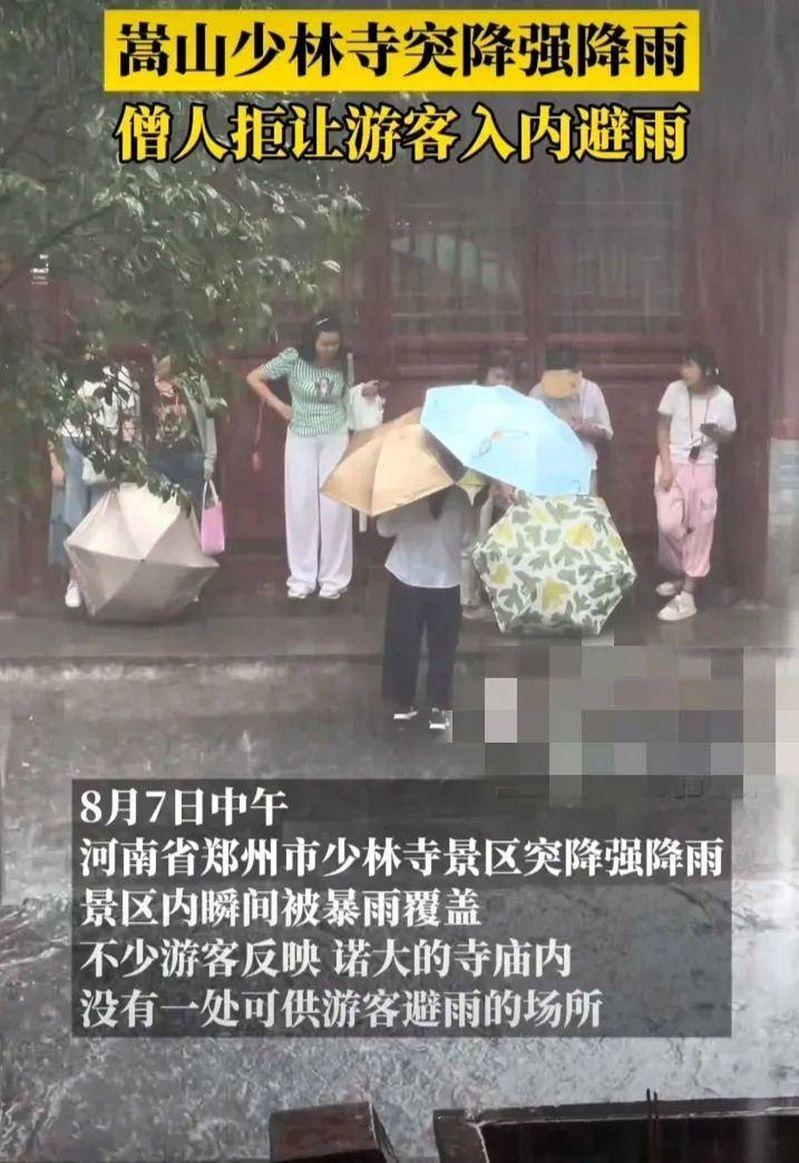 少林寺拒绝游客进入室内,多人被迫挤在屋檐下避雨。(视频截屏)