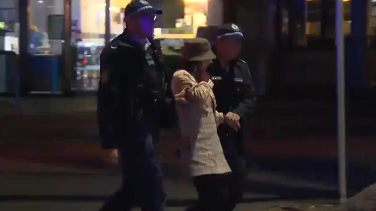 杨兰兰被护送离开现场。(取材自潇湘晨报)
