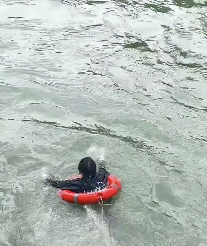 白玛初抱住落水者，救生圈被水流冲走。（视频截屏）