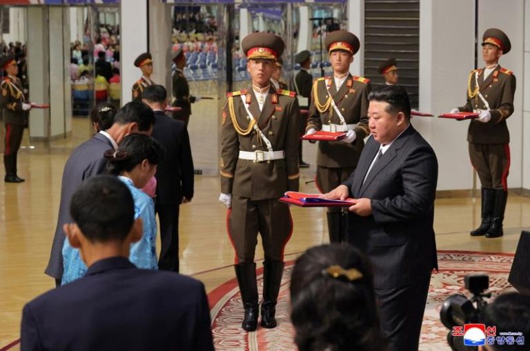 金正恩(中排右)29日会见在乌克兰阵亡官兵的遗族。(路透)