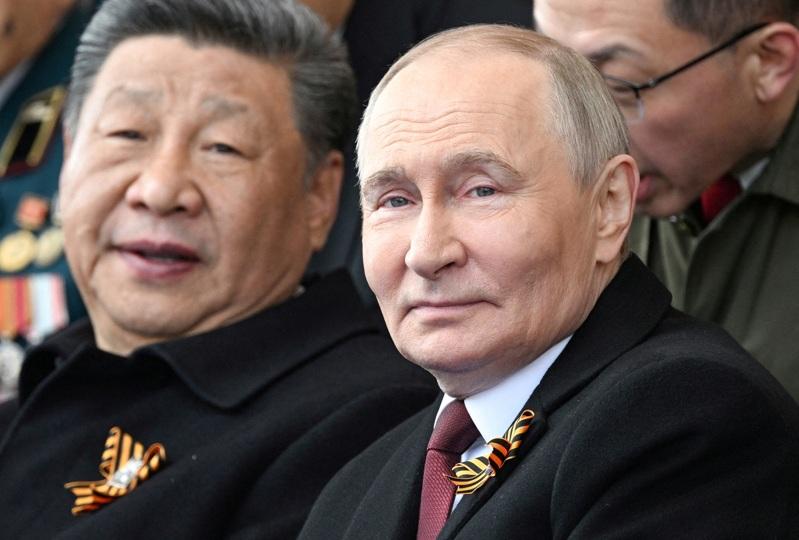 俄罗斯总统普亭(右)与中国国家主席习近平出席在莫斯科市中心红场举行的阅兵典礼。(路透)