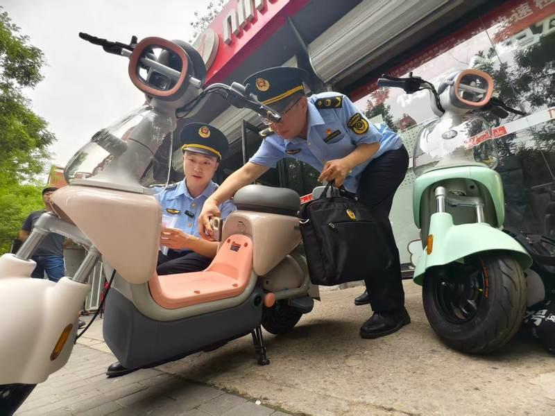 执法人员在检查新电动自行车是否合规。(取材自新京报)