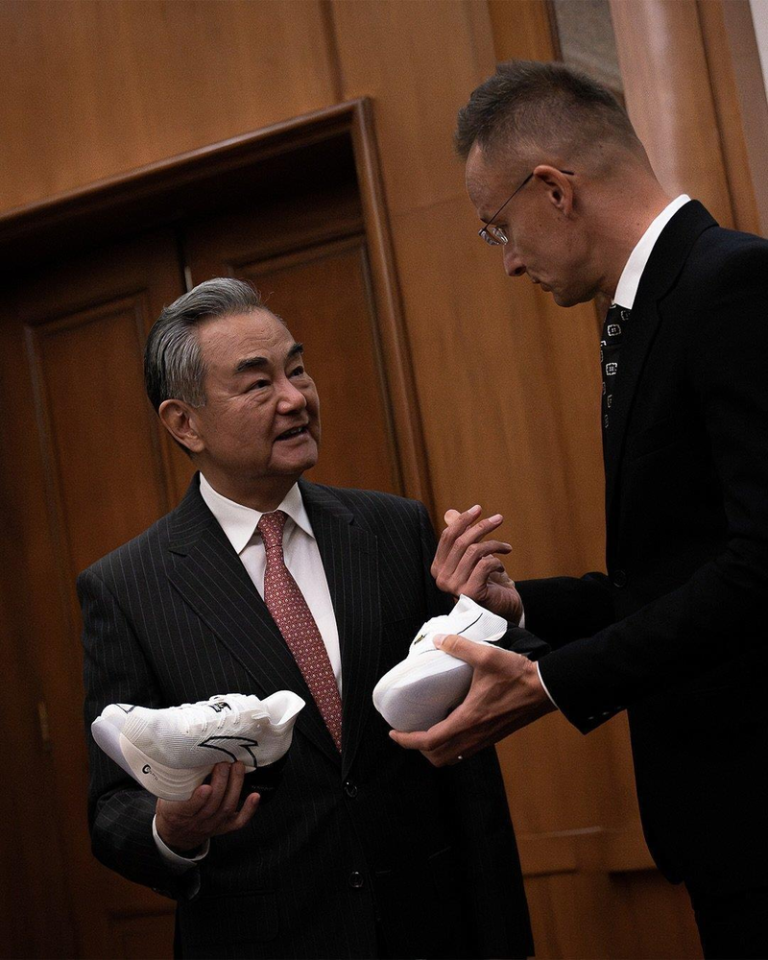 外交部长王毅（左）赠送匈牙利外长西亚尔托国产跑鞋。（取材自环球时报）
