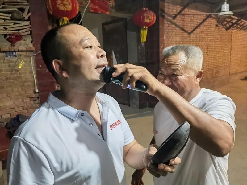 艳飞砖厂打包在线，几名工人正在将砖块放在打包流水在线，由末端的机械手将砖块打包成捆。（取材自新京报）