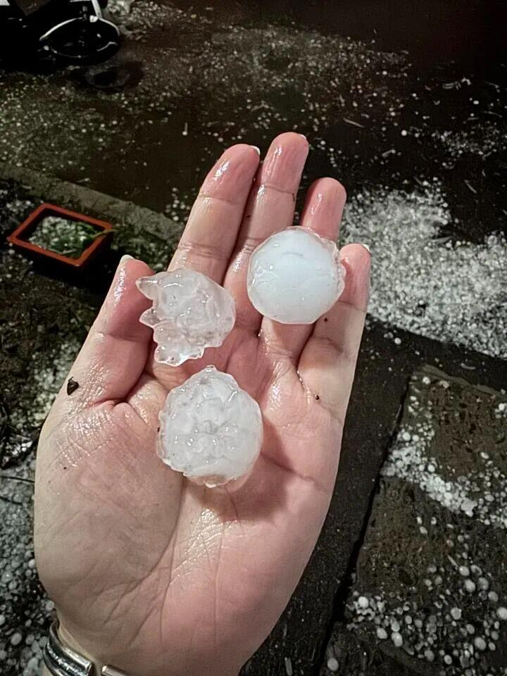 网友发布冰雹漂浮在路面雨水上，仿佛漂浮的冰河景象。（取材自北京交通广播）