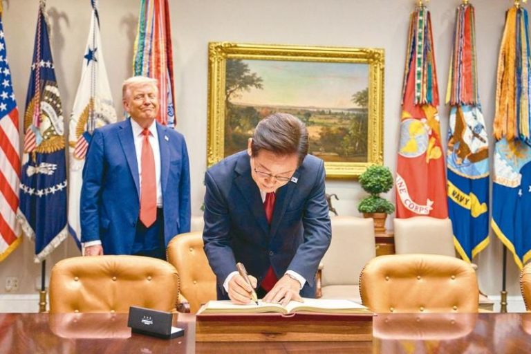 南韩总统李在明（前）日前接受美国时代杂志专访时，重申美韩会站在一起，但南韩也不能因此疏远中韩关系。图为8月白宫「川李会」时，美国总统川普（后）微笑看着李在明在访宾簿上签名。(欧新社)