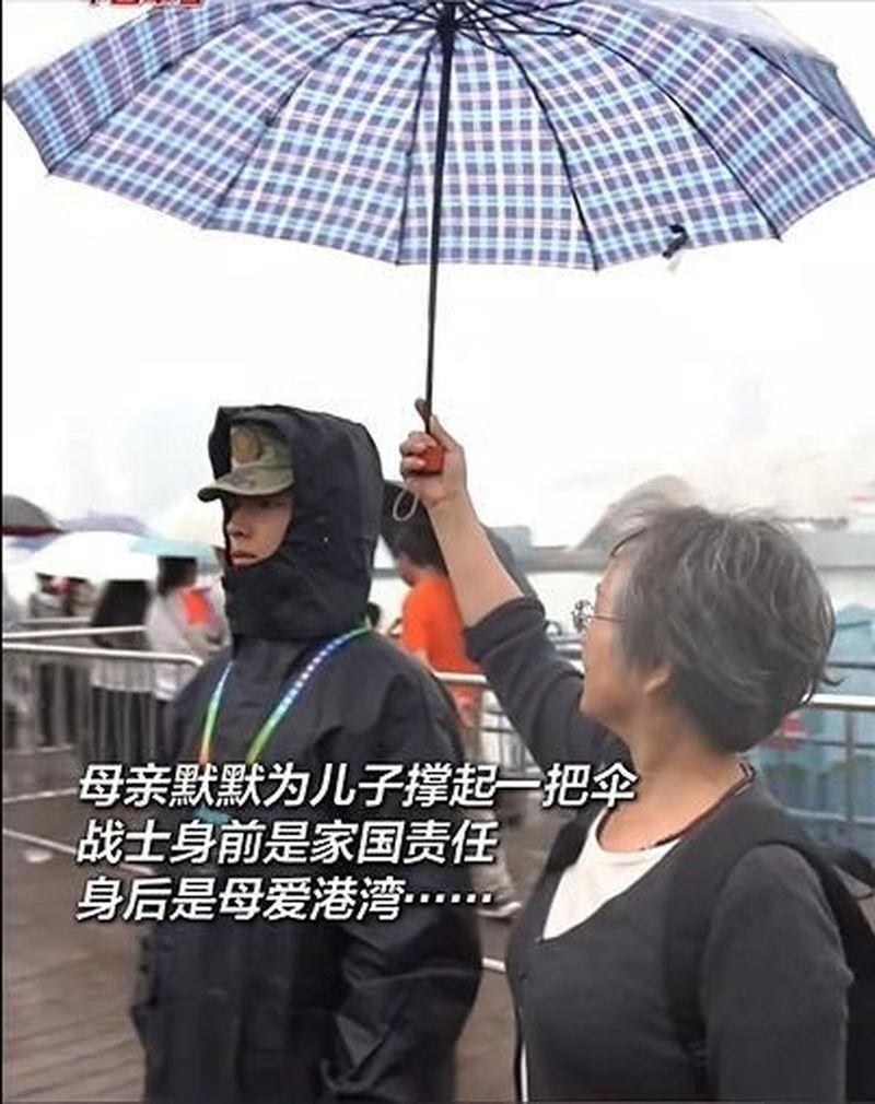 河南商丘的兵妈妈，撑着伞望着执勤中的儿子。（取材自大象新闻）