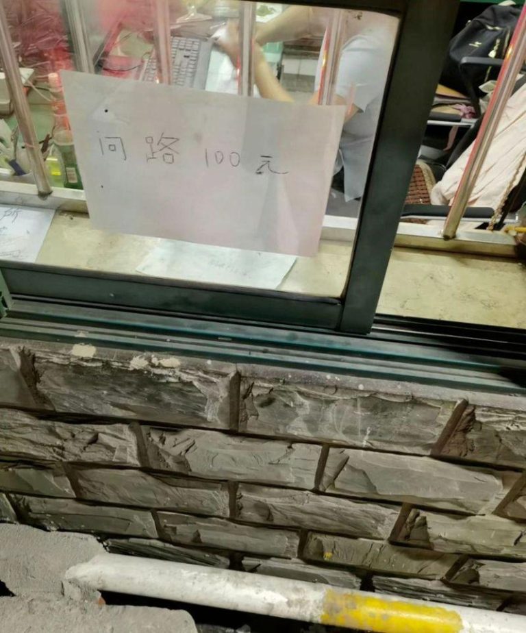 窗口贴出「问路100元」的标示。（取材自红星新闻）