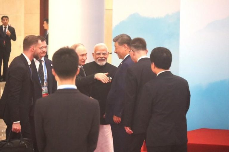 中俄印三国领导人习近平、普亭、莫迪在上合峰会合影时，热烈交谈。（记者廖士锋／摄影）